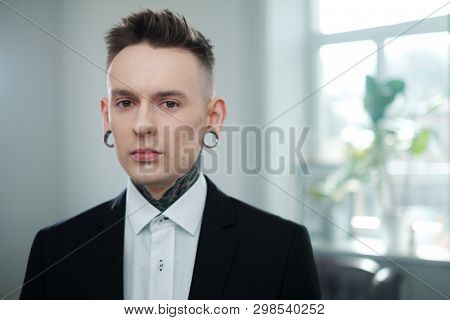 Portrait of alternative model with earplugs and tattoo