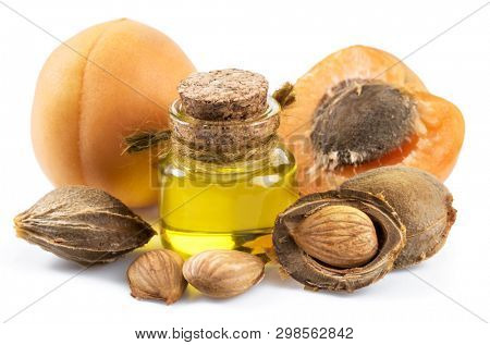 Apricot kernel oil and apricot kernels isolated on the white background.