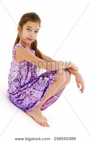 A Cute Little Girl Leaned Against A White Wall. Cyclorama In Studio. Isolated On A White Background.
