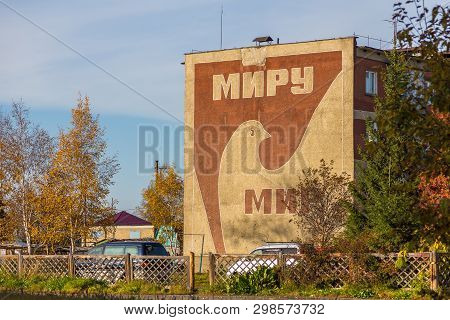Milkovo, Kamchatka, Russia- 27 September 2014: View Of The Peace Symbol, Dove, On The Facade Of A Bl