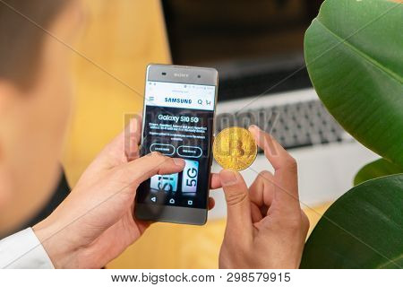 Etrade Website On A Smartphone And Businessman Trader Holding Bitcoin.