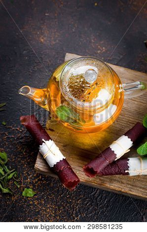 Hot Herbal Tea In A Tea Pot, Leaves Fresh Mint, Dry Fruits Leather Roll And Dry Mint Leaves With Str