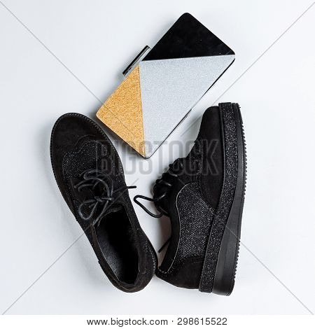 A Pair Of Black Shoes With Shiny Inserts On A Thick Sole And A Three-color Clutch Bag With Sparkles 