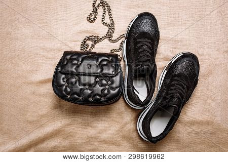 Black Sneakers On A White Thick Sole Decorated With Black Sparkles And A Black Clutch With Asterisks
