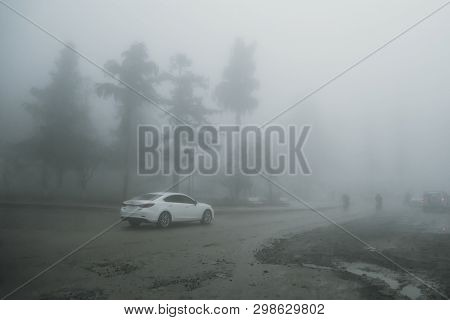 Poor Visibility In Fog On Road. Car Slowly Driving In Dangerous Weather. Dark Time. Traffic Concept