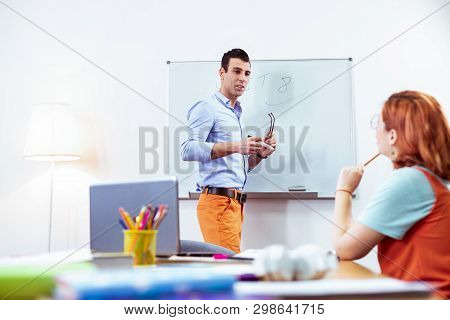 Nice Pleasant Young Man Taking Off His Glasses