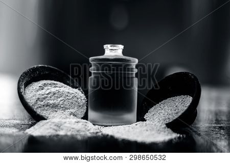 Close Up Of Organic Oil Of Poppy Seeds Or Khus Khus In A Small Glass Bottle With Raw Poppy Seeds And