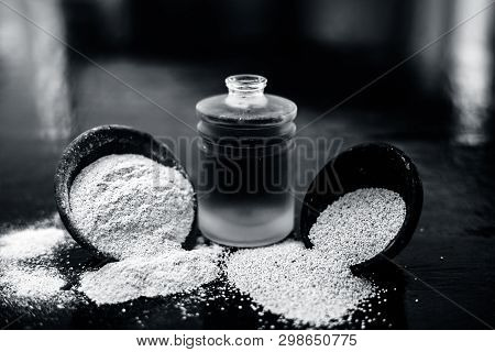 Close Up Of Organic Oil Of Poppy Seeds Or Khus Khus In A Small Glass Bottle With Raw Poppy Seeds And