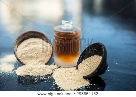 Close Up Of Organic Oil Of Poppy Seeds Or Khus Khus In A Small Glass Bottle With Raw Poppy Seeds And