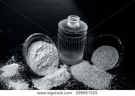 Close Up Of Organic Oil Of Poppy Seeds Or Khus Khus In A Small Glass Bottle With Raw Poppy Seeds And