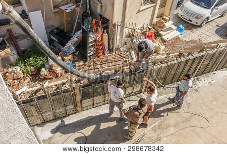Limassol, Cyprus - April 3, 2018:  Man Standing On Shuttered Wall Holding The Chute And Pouring Ceme