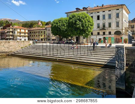 Luino, Lombardy, Italy - April 30, 2019: People Resting On The Lakefront Of Luino, Located On The Co
