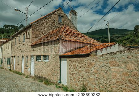 Facade Of Old Stone Wall House With Wooden Door, In A Deserted Alley At Unhais Da Serra. A Small And