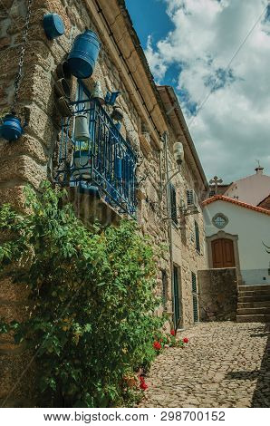 Facade Of A Rustic Stone House With Decorated Balcony On A Cobblestone Alley At Alvoco Da Serra. A C