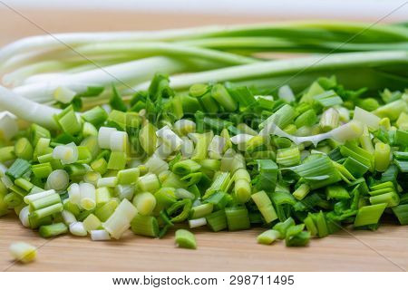 Chopped Green Garlic On Cutting Board Preparated For Cooking. Close-up Photo With Selective Focus.