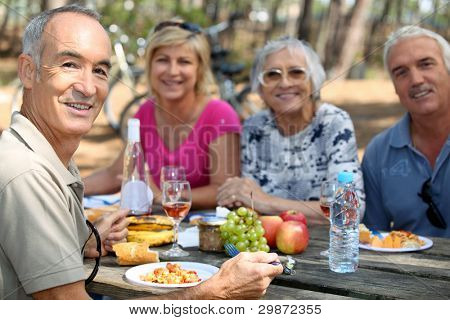 семья ест пикник в лесу