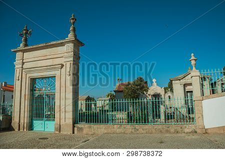 Guarda, Portugal - July 21, 2018. Cemetery Gateway With Iron Fence Encircling Crypts And Marble Tomb