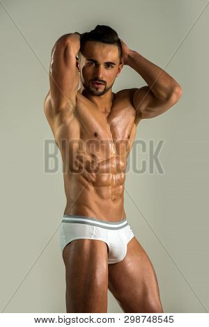Young Man With Perfect Body. Naked Male Model In Seductive And Sexy Pose Wearing Only White Underwea