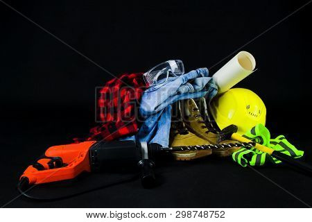 Work Tools For Construction Worker  On Black Background.yellow Crash Helmet, Red Checkered Shirt, Je