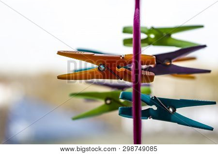 Multi-colored Clothespins Are Attached To A Hanger For Storing Shawls, Scarves And Stoles. Selective