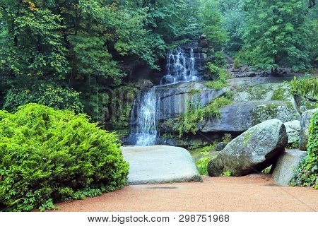 A Picturesque Cascade Waterfall Among Large Moss Covered Stones In The Landscape Sophia Park, Uman, 
