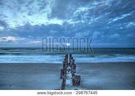 Moonset At Dawn Over A Dilapidated Pier On The Beach In Port Royal