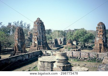 Buddhist Stupas Stand Among The Ancient Ruins Of Wat Phra Mahathat In Ayutthaya, Thailand.