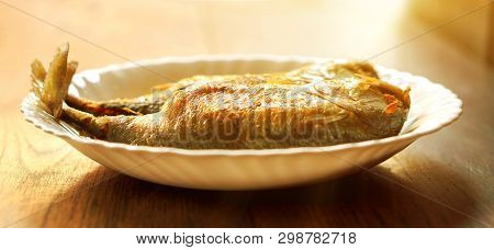 Closeup Fried Mackerels On White Ceramic Plate And Wooden Table With Sun Flare Background. Fried Mac