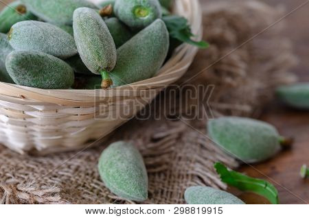 Fresh Green Unripe Almonds In Basket On Wooden Table