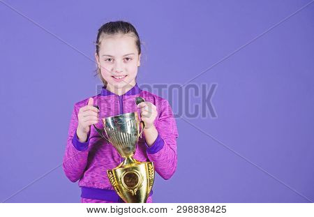She Is The Best. Small Girl Holding Silver Cup. Little Child With Cup Shaped Sports Trophy. Cute Ath