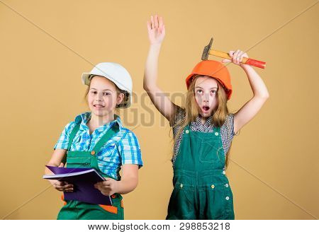 Little Kids In Helmet With Tablet And Hammer. Labor Day. 1 May. Small Girls Repairing Together In Wo