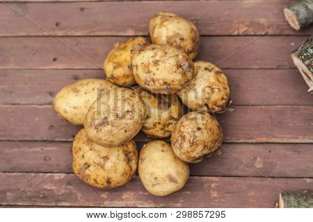 Many Fresh Potatoes On The Brown Table