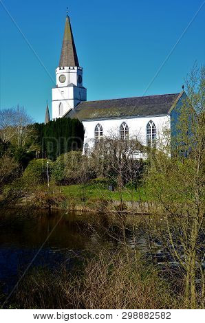 A View Of The White Church Building On The Banks Of The River Earn In Comrie, Perthshire