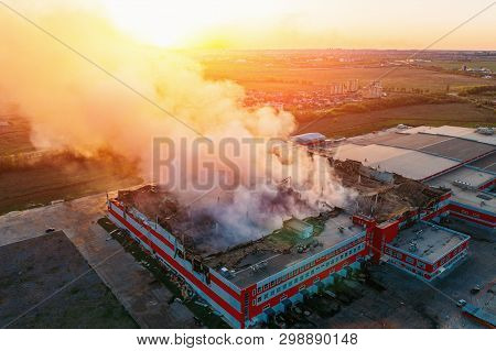 Heavy Smoke In Burning Industrial Warehouse Or Storehouse Industrial Hangar From Burned Roof, Aerial