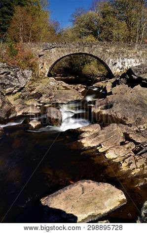 A View Of The Old Stone Bridge Which Spans The Falls Of Dochart At Killin.