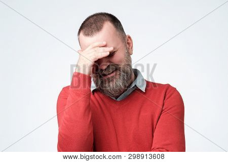 Mature Man Making Facepalm Gesture, Covering Eyes.