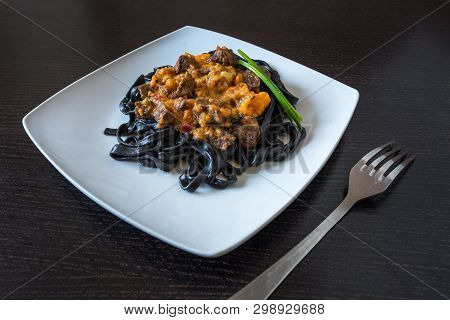 Black Pasta With Cuttlefish Ink. Pasta Of Durum Wheat Semolina With Squid Ink With Beef And Sweet Pe