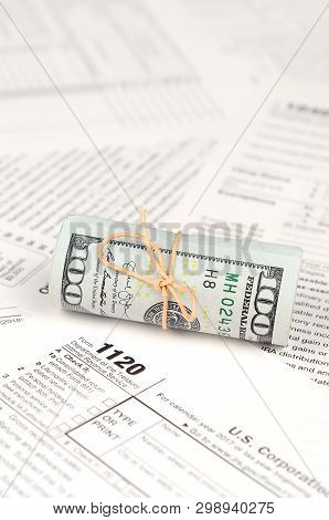 1120 U.s. Corporation Income Tax Return Form With Roll Of American Dollar Banknotes
