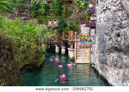 XCARET,MEXICO - APRIL 16,2019 : Visitors enjoying the underground river at the XCaret park on the Mayan Riviera