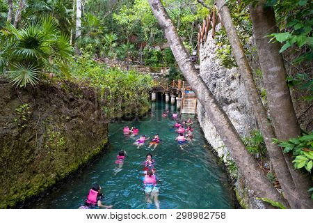 XCARET,MEXICO - APRIL 16,2019 : Visitors enjoying the underground river at the XCaret park on the Mayan Riviera