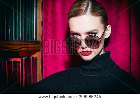 A portrait of a confident lady wearing sunglasses. Beauty, make-up, style.