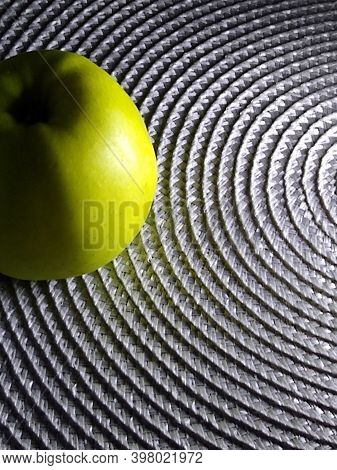 Green Apple Close-up On A Silver Textured Background With Hard Lighting. High Quality Photo