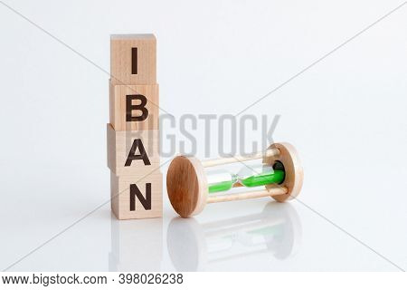 Close-up Of An Hourglass Next To Wooden Blocks With The Text Iban