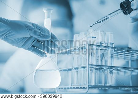 Conical Flask In Scientist Hand With Lab Glassware Background, Laboratory Research Concept