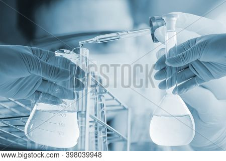 Conical Flask In Scientist Hand With Lab Glassware Background, Laboratory Research Concept