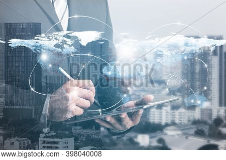 Double Exposure Of Success Businessman Using Digital Tablet With City Landscape Background.connectio