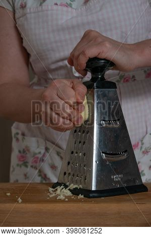 Womens Hands Rub Cheese On A Metal Grat
