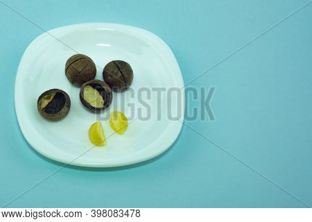 Macadam Closed And Open Nuts On A White Plate.