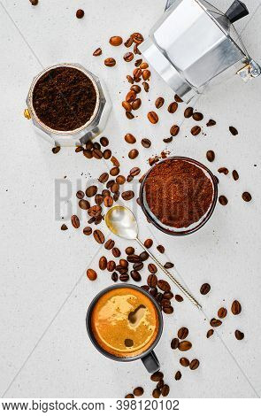 Cup With Ristretto, Ground Coffee In A Mug And Coffee Pot And Coffee Beans On A Gray Table. Top View