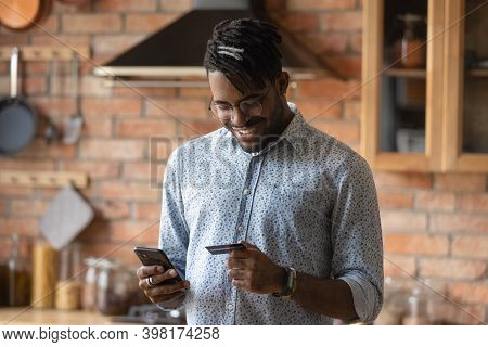 Smiling 30s African Ethnicity Biracial Man Shopping In Mobile App.